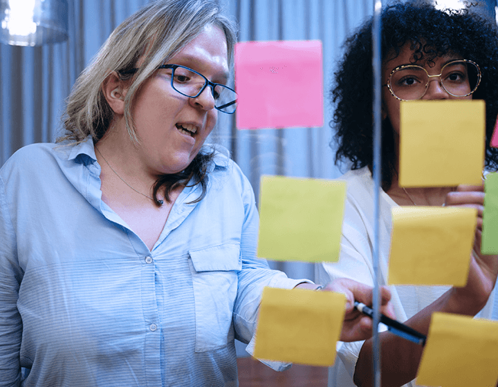 Two people working at a whiteboard